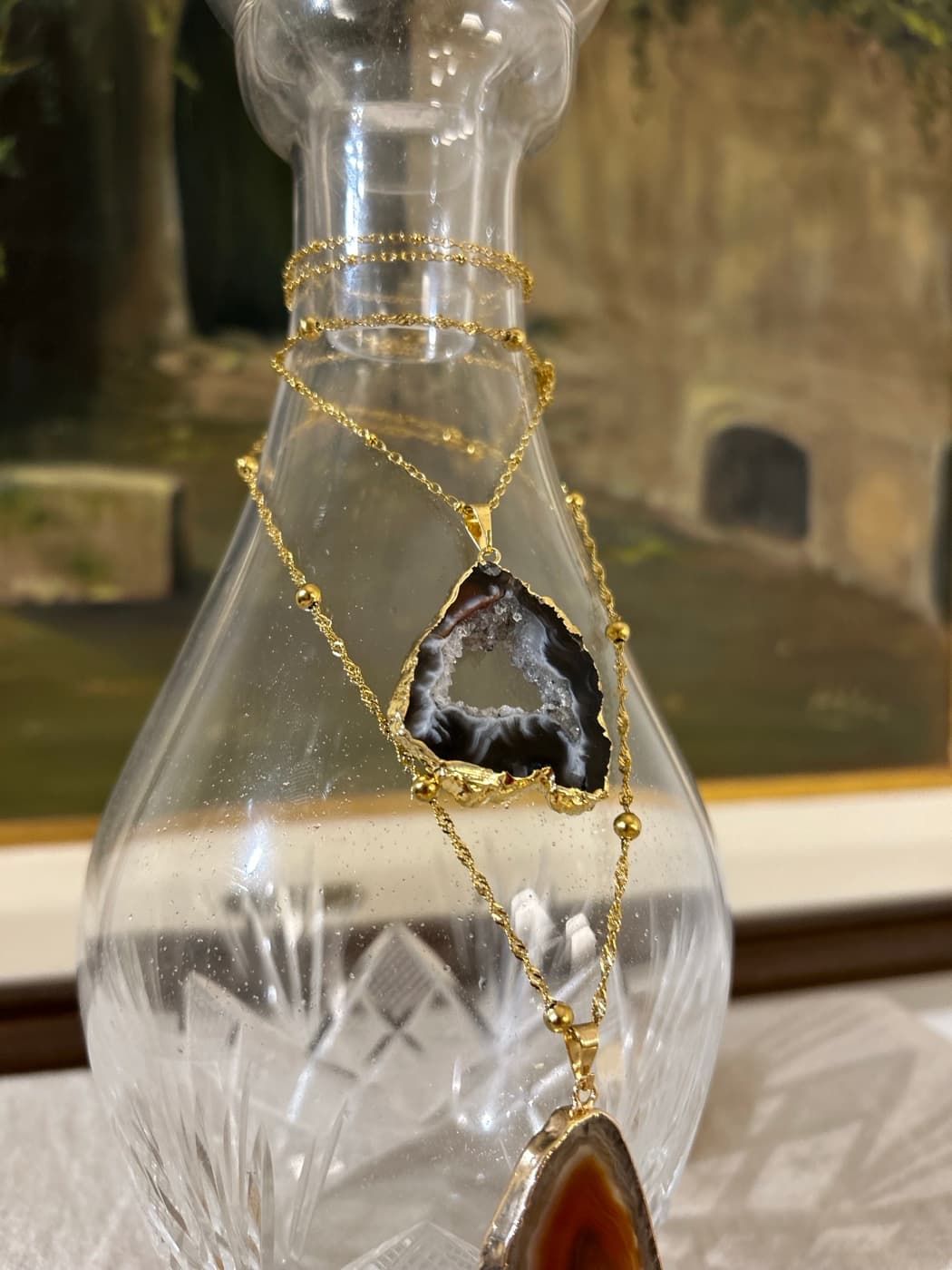 Detalle de una piedra singular en cadena de eslabones dorados.