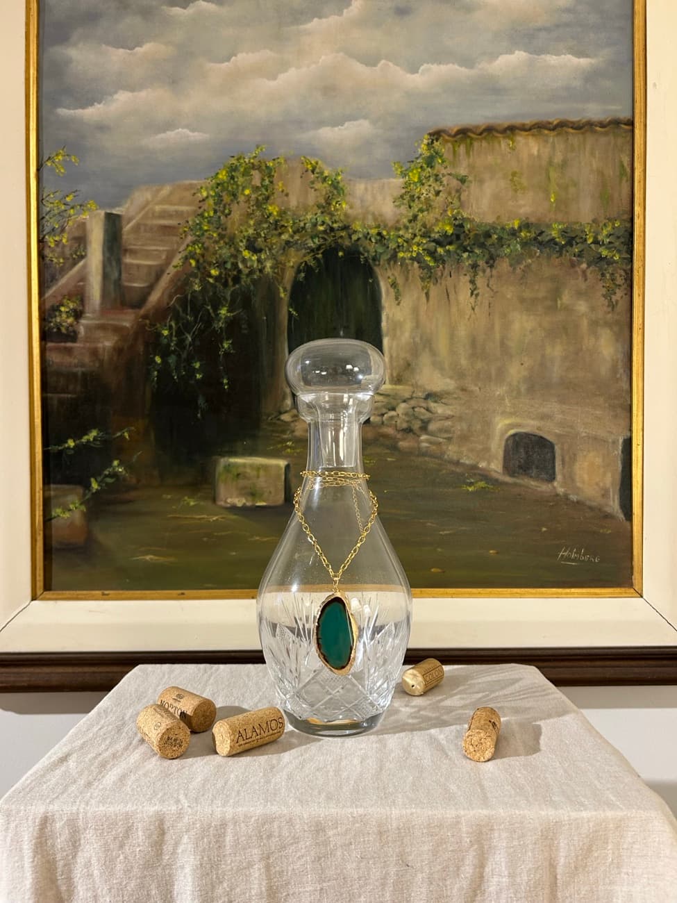 Licorera de cristal con un dije de piedra verde.