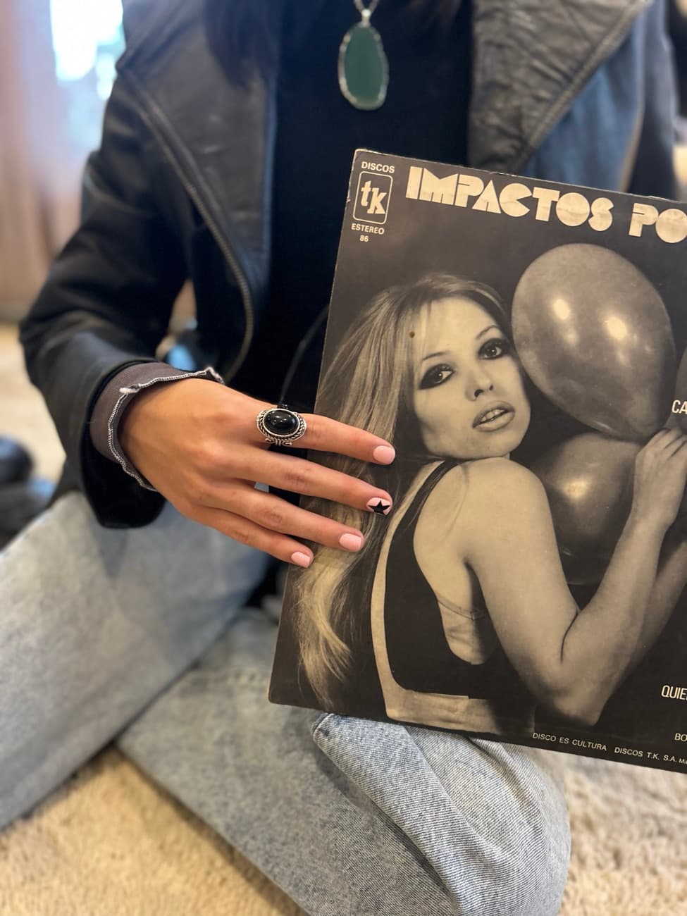 Dije de piedra verde junto a una revista antigua.