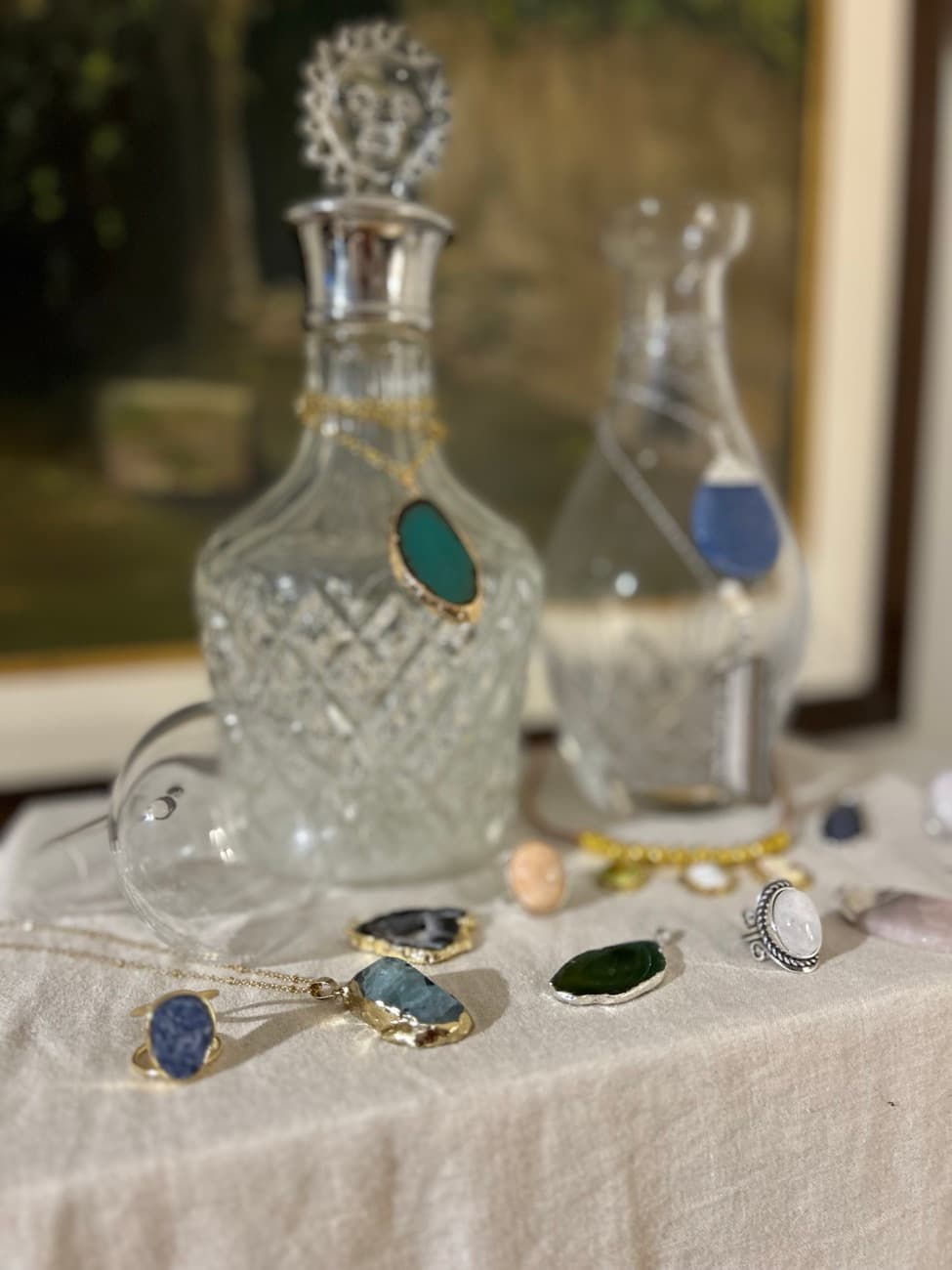Licoreras de cristal y varios dijes de piedra sobre lino.